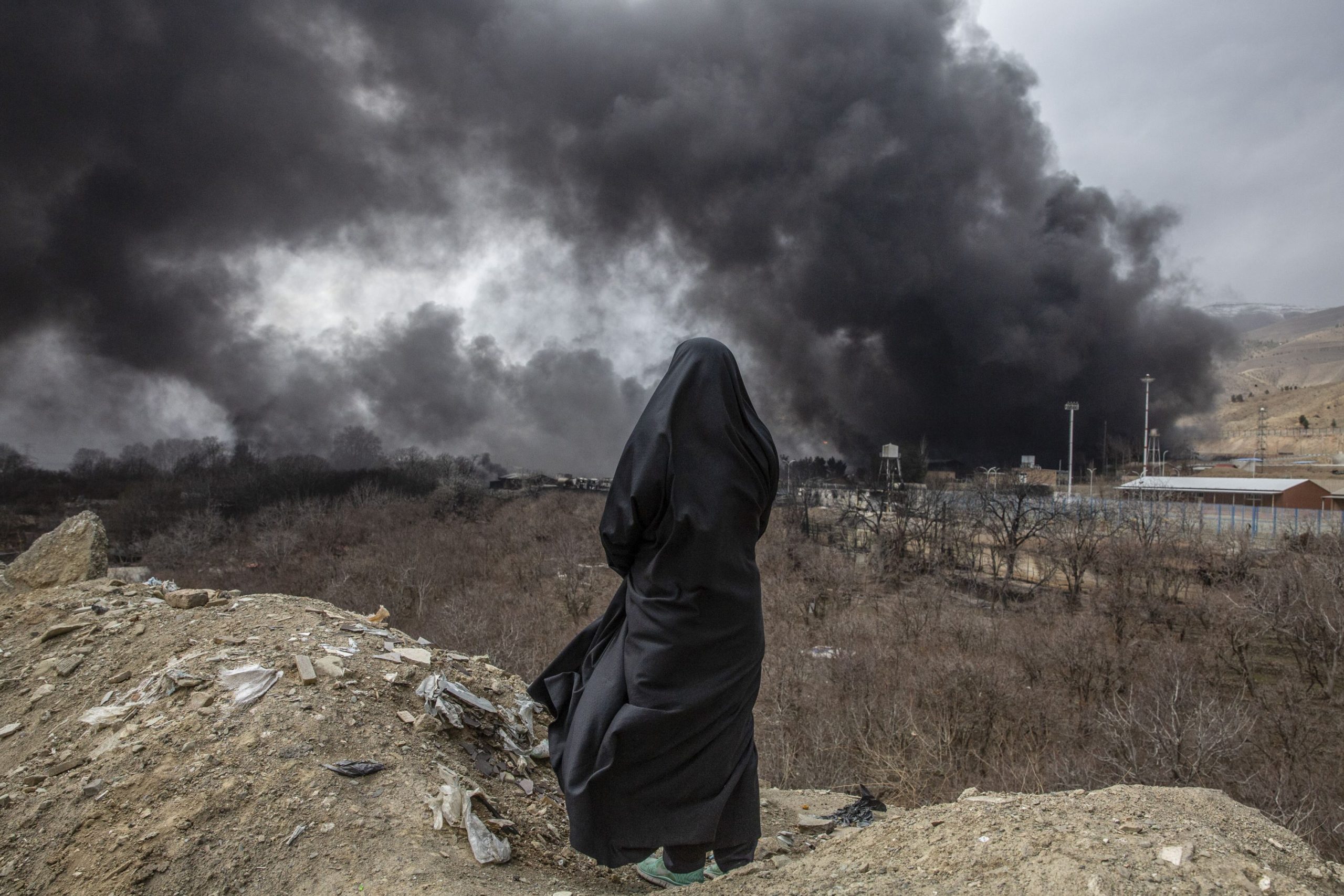 Woman gazing at destruction in Iran